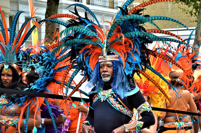 carnival procession. person in blue and orange headdress