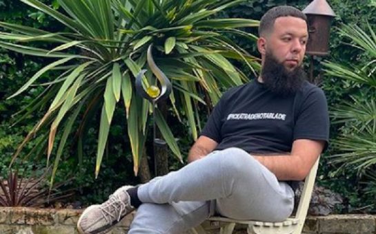 Hafid sitting in a chair in a garden with plants in the background