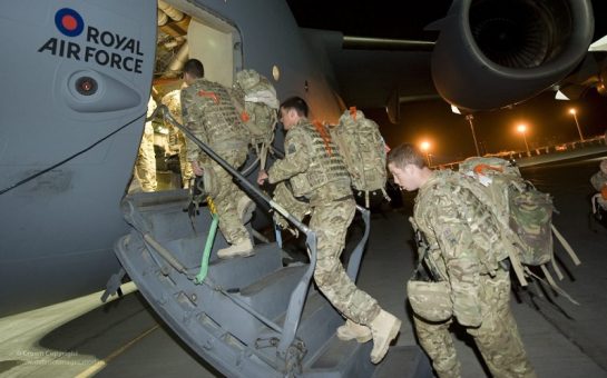 British army troops walking up a ramp into a cargo plane to return to the UK from Afghanistan