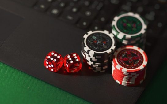 dice and poker chips on a laptop