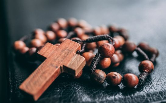 A wooden cross and prayer beads