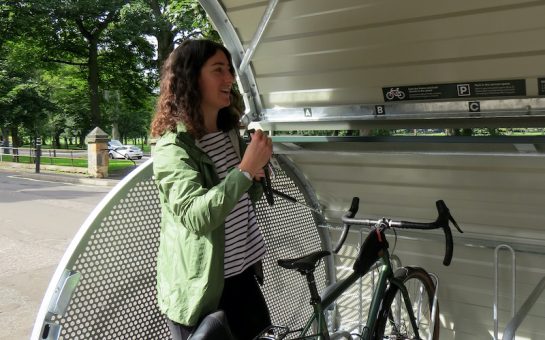 Woman locking her bike in storage space