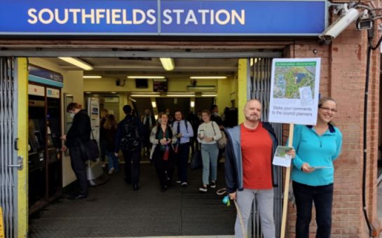 Wimbledon residents holding up a placard outside Southfields tube station.