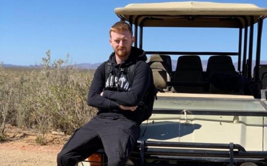 Billy Hood sits on the front of a car