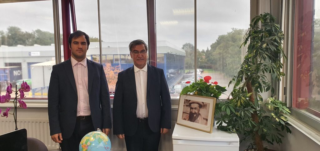 Dr Nooralhaq Nasimi stands with his son and a picture of his father