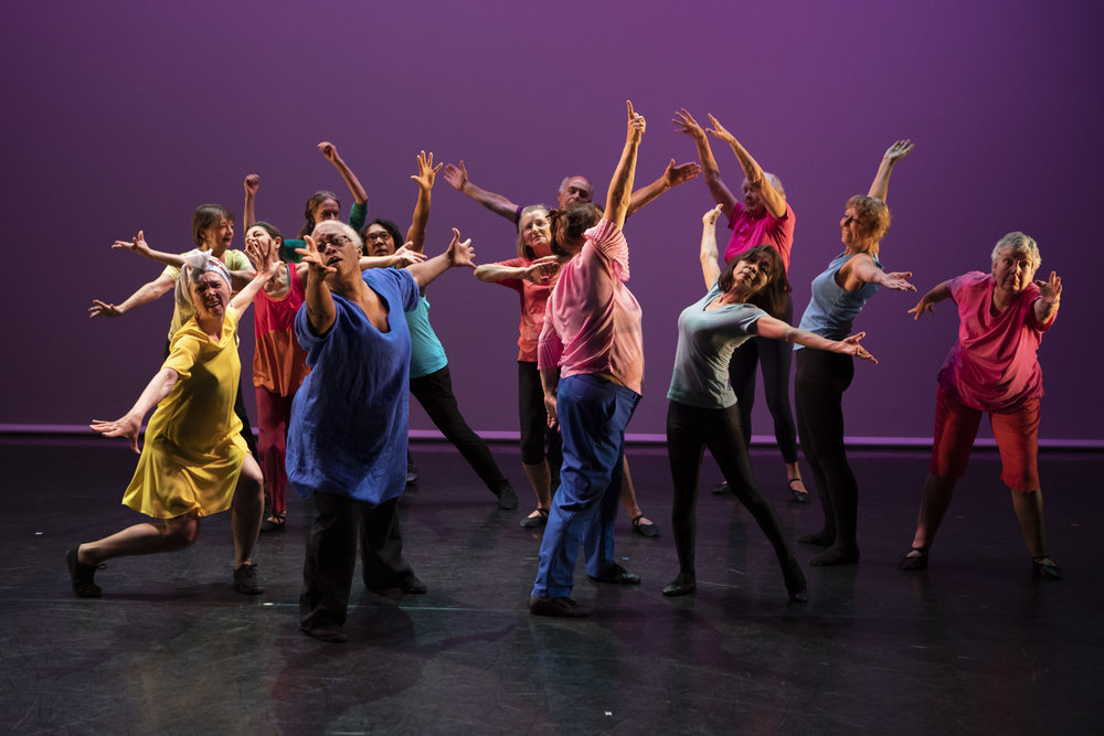 Thirteen dancers, aged 55 and up, striking elaborate poses.