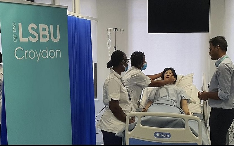 A photo of student nurses training on a dummy in a replica hospital ward in London South Bank University's new Croydon campus