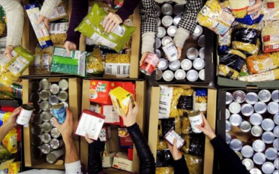 hands reaching towards food in a food bank