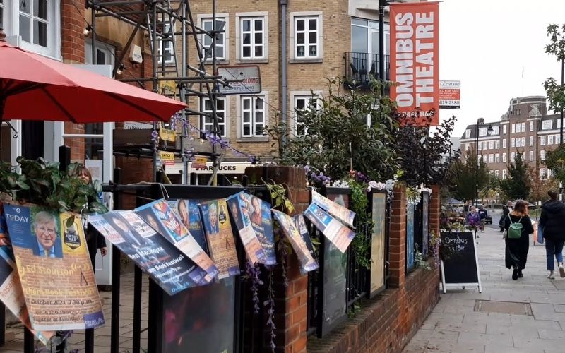 Flyers adorn a fence outside the Omnibus Theatre, identified by a red sign, on the day of the Clapham Book Festival