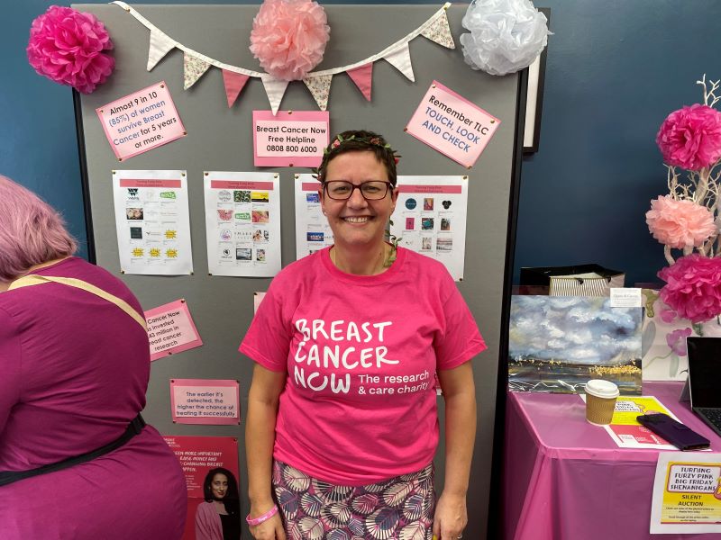 Godsiff in front of a Breast Cancer Awareness board at the fundraiser.