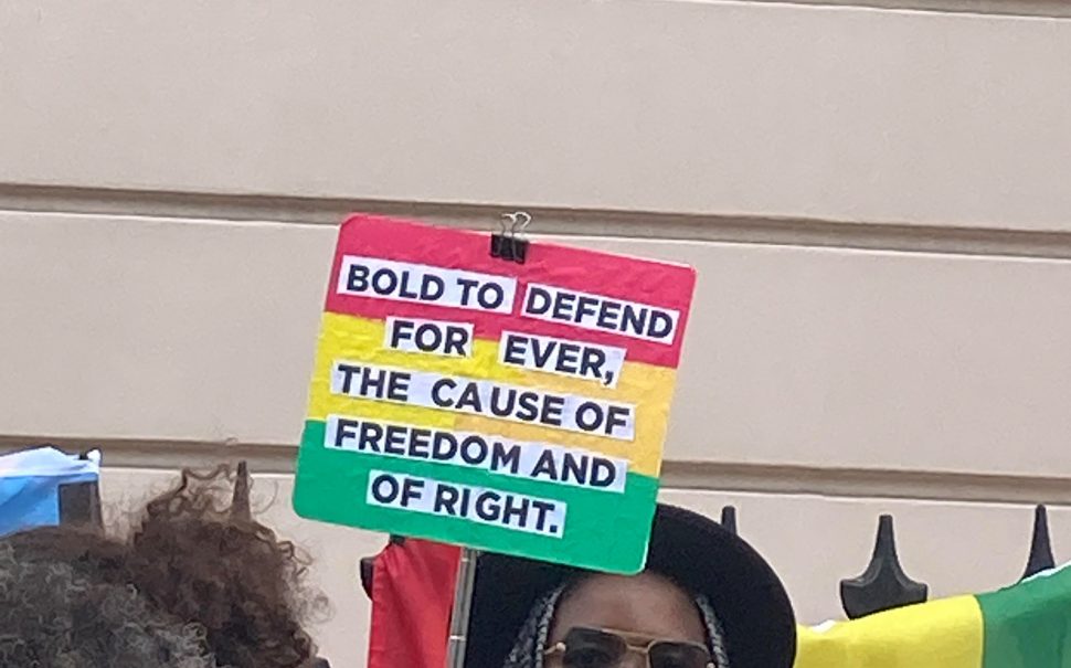 Protest sign with the Ghana flag colours about defending freedom