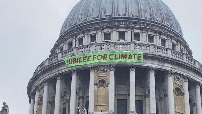 Banner dropped on Paternoster Square that says 'jubilee for climate'.