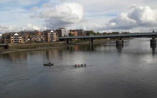 A rowing boat and a small coxing boat on the Thames, seen from Putney Bridge