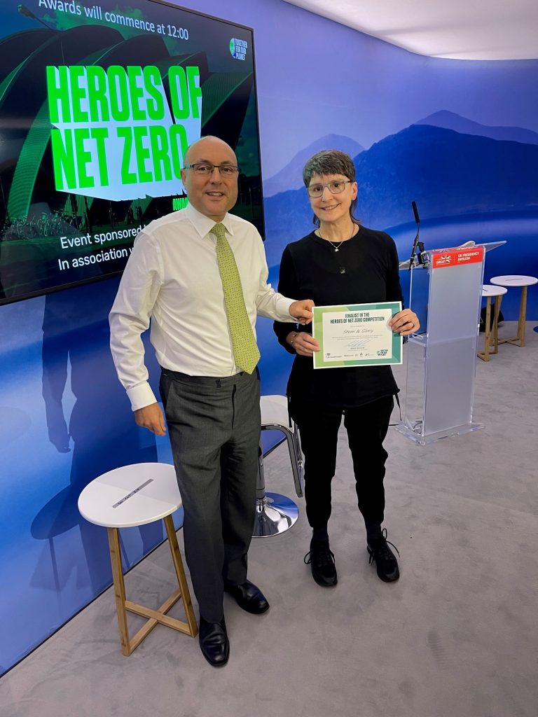 CEO of vegan restaurant chain Stem & Glory holding a certificate for being a finalist in the Heroes of Net Zero competition 