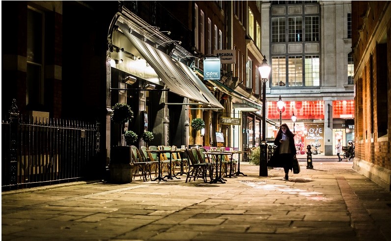 Woman walking alone at night through Kensington
