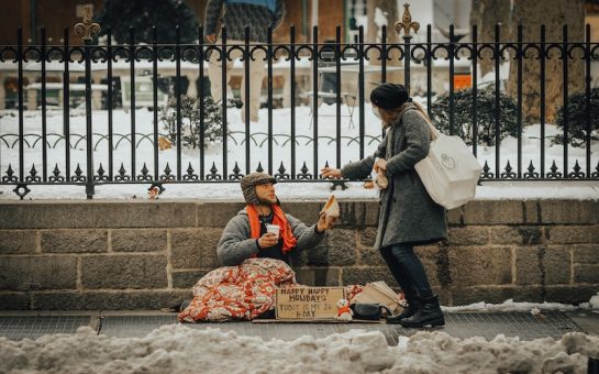 woman handing rough sleeper food