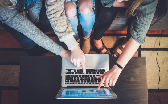 people using computer pointing at screen