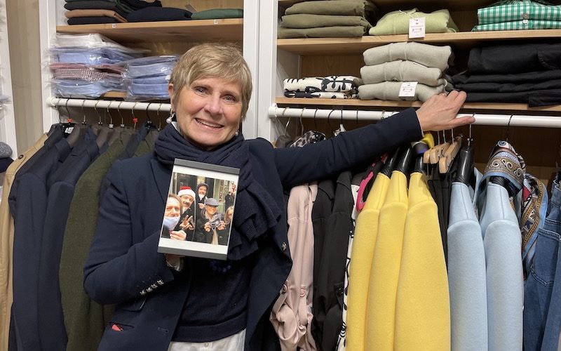 Shop owner Christina Lelli holds photograph of Ted Lasso crew.