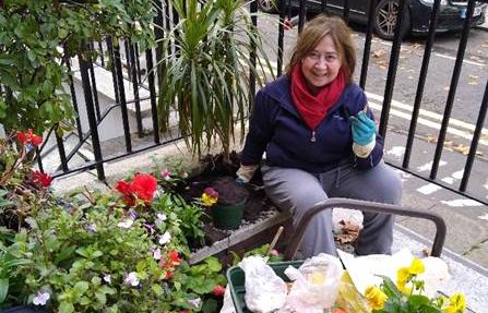 C&C resident Myriam poses in her garden as she plants flowers