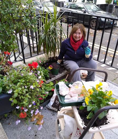 C&C resident Myriam poses in her front garden as she plants some flowers. She uses gardening to help with her feelings of loneliness. Image credit: CCHT