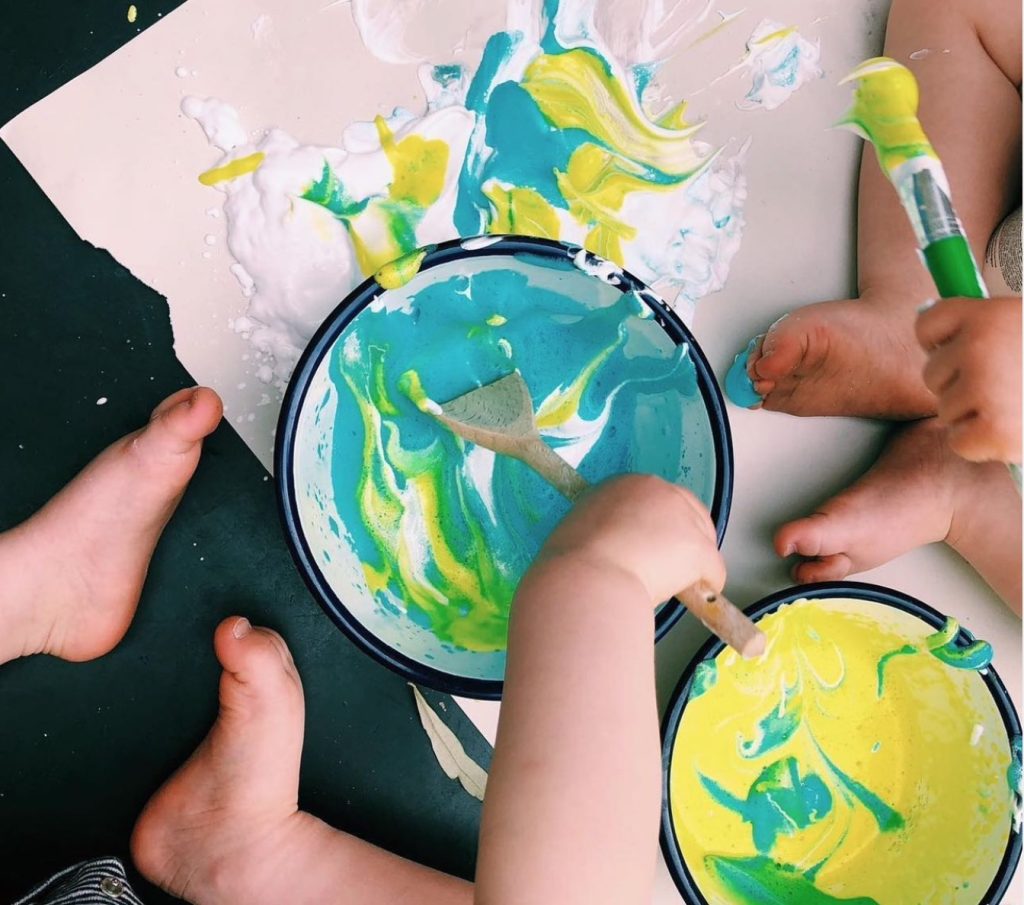 An example of sensory play which shows children playing with paint and washing-up liquid