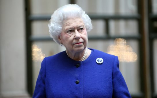 The Queen dressed in navy blue with a qhite background including black framing