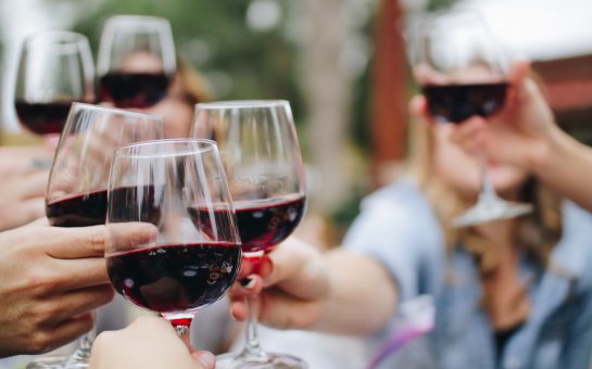 People with wine glasses in their harnds