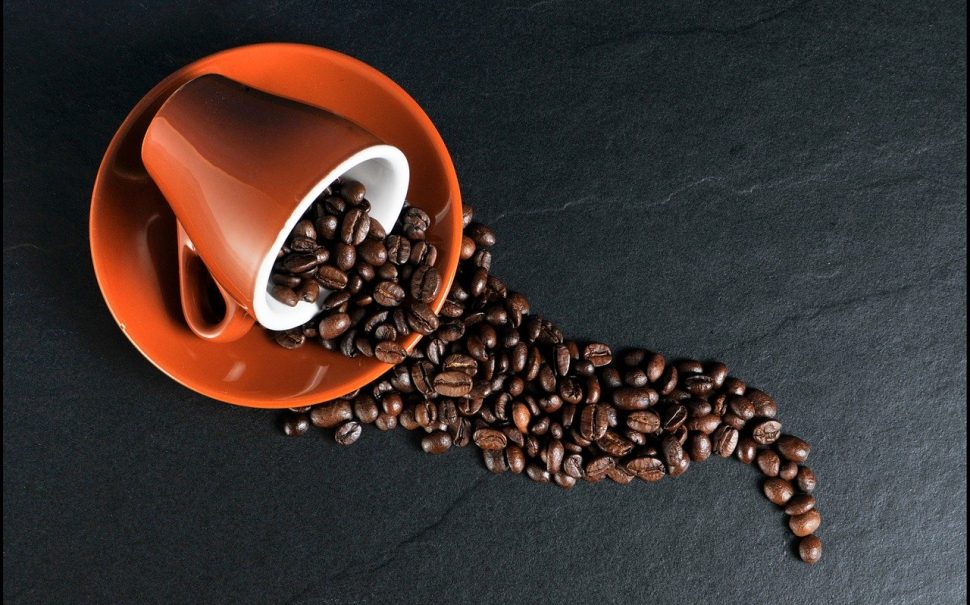 coffee beans falling out of a cup