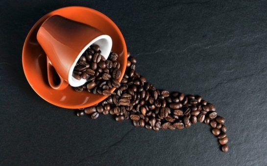 coffee beans falling out of a cup