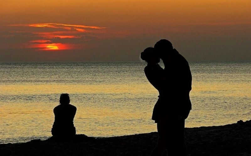 silhouette of two people kissing on a beach
