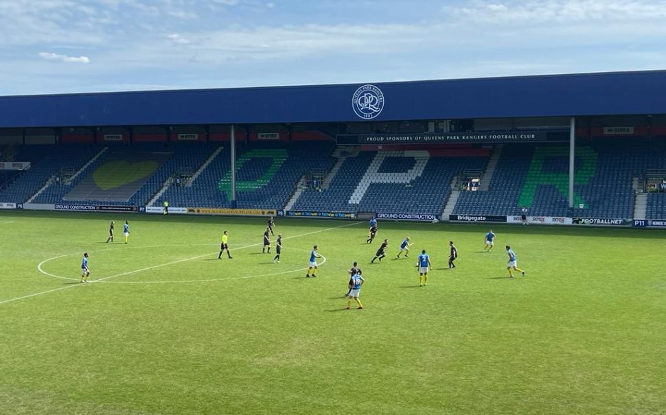 Players on the pitch of QPR's stadium.