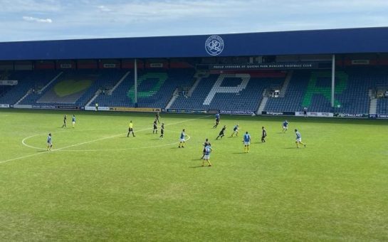 Players on the pitch of QPR's stadium.