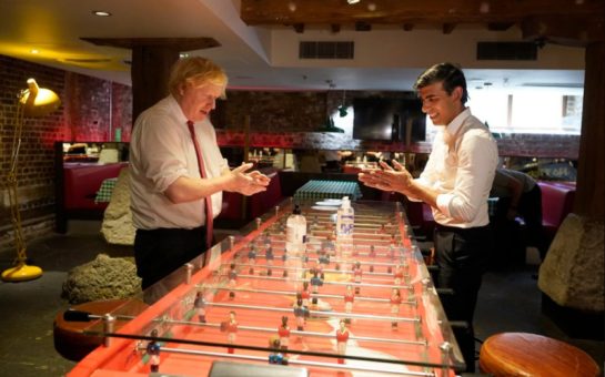 Boris Johnson and Rishi Sunak over a table