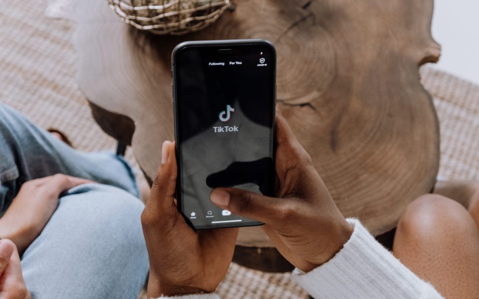 Woman holding phone with TikTok on screen