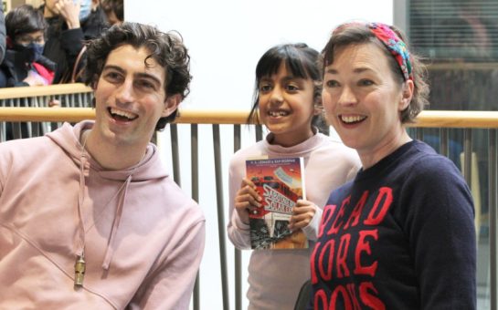 Author posing for a picture with child at the book club