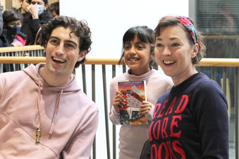 Author posing for a picture with child at the book club