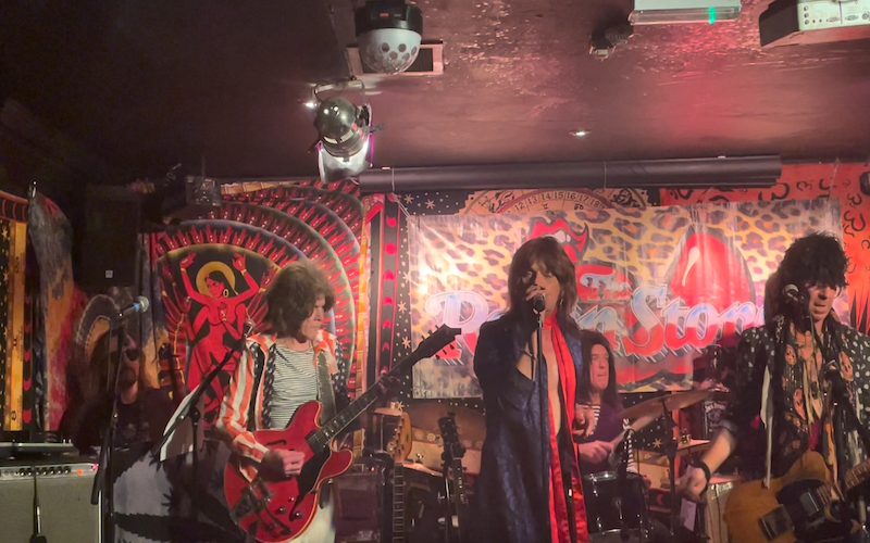 An image of The Rollin' Stoned ban performing on stage at the Eel Pie Club. It is very vibrant.