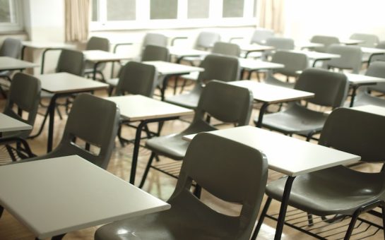 A picture of rows of classroom desks and chairs. There are no people sitting on the chairs. This is to symbolise permanent exclusions..