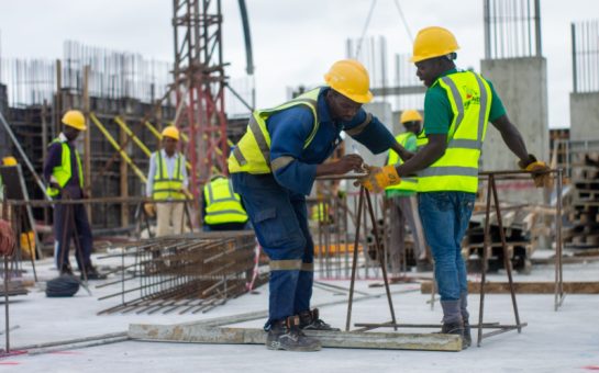 2 groundworkers on a construction site putting in rebar for foundations