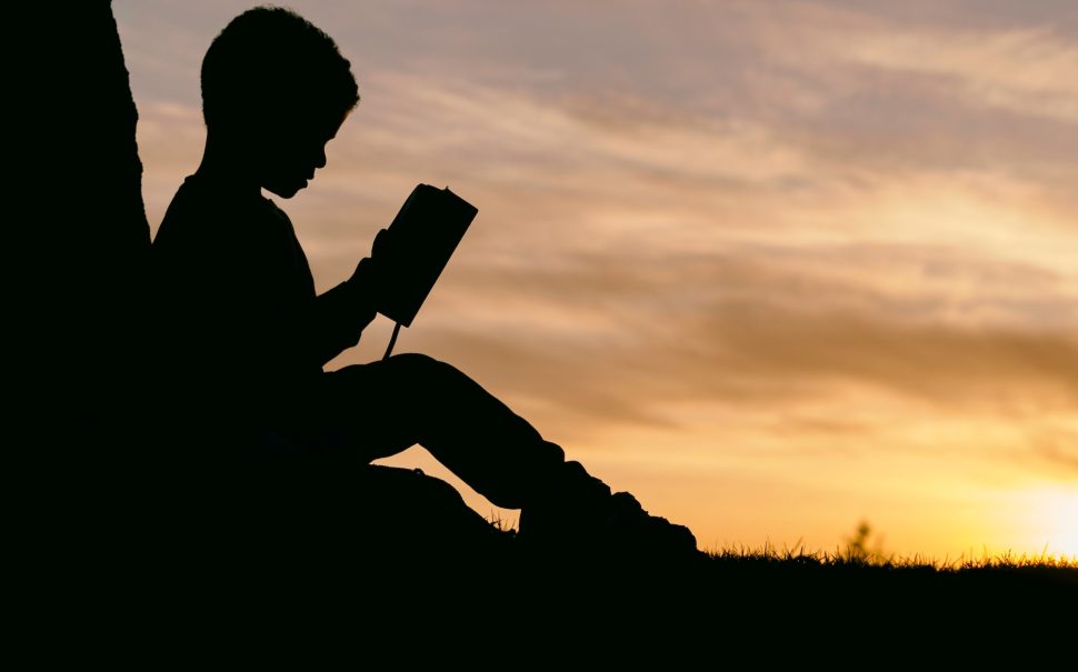 Silhouette of a child on their phone