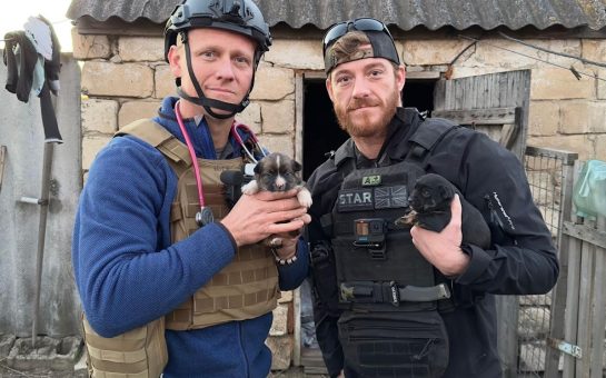 Doctor Scott Miller and a member of Breaking the Chains with puppies.