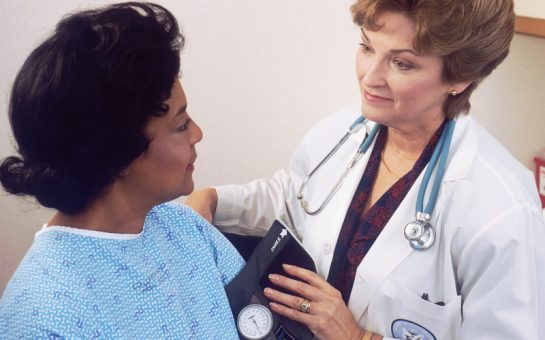 doctor taking patient blood pressure