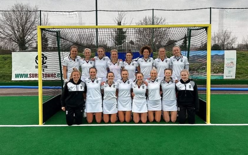 Surbiton Hockey Club's ladies team photo, taken with them all together in a hockey net