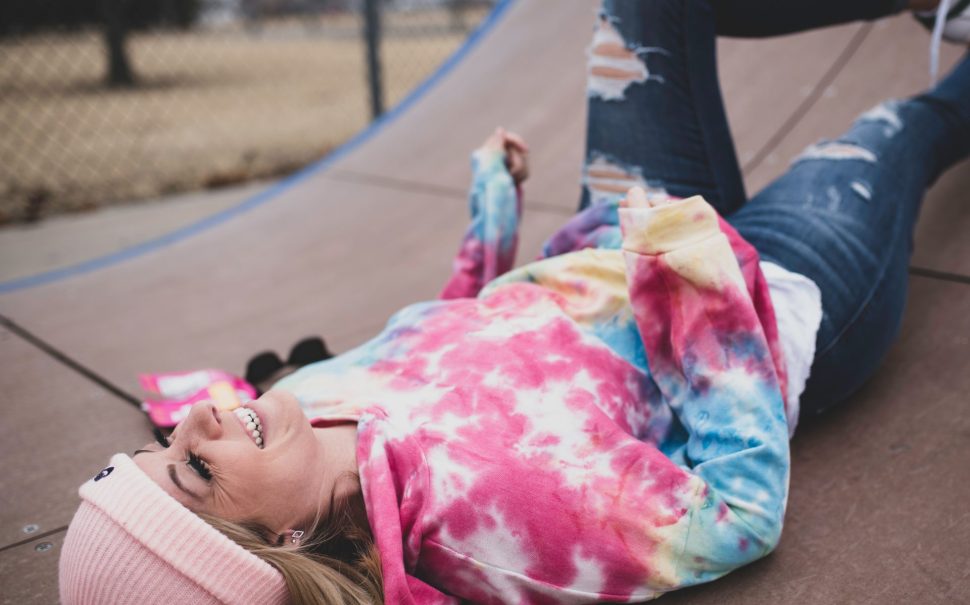 A person wearing tie dye with a hat on