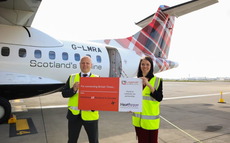 Two people standing to commemorate the first Loganair Shetland flight