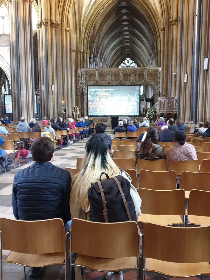People watch the Coronation on a big screen in Bristol Cathedral