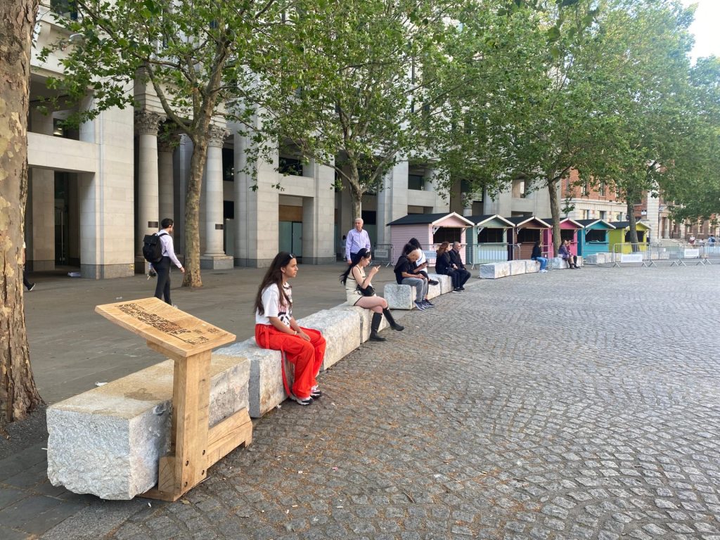 Visitors and passers-by sitting on the granite stones relocated by the project "From Thames to Eternity" near St Paul's Cathedral. 
Credit: Morgane Guillou