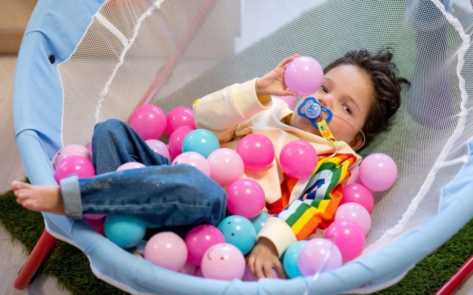 Spencer Smit, 4, at a Sense Connect and Play session. Spencer is playing with pink and blue pastic balls.