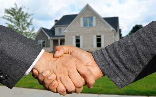 Handshake in front of a house