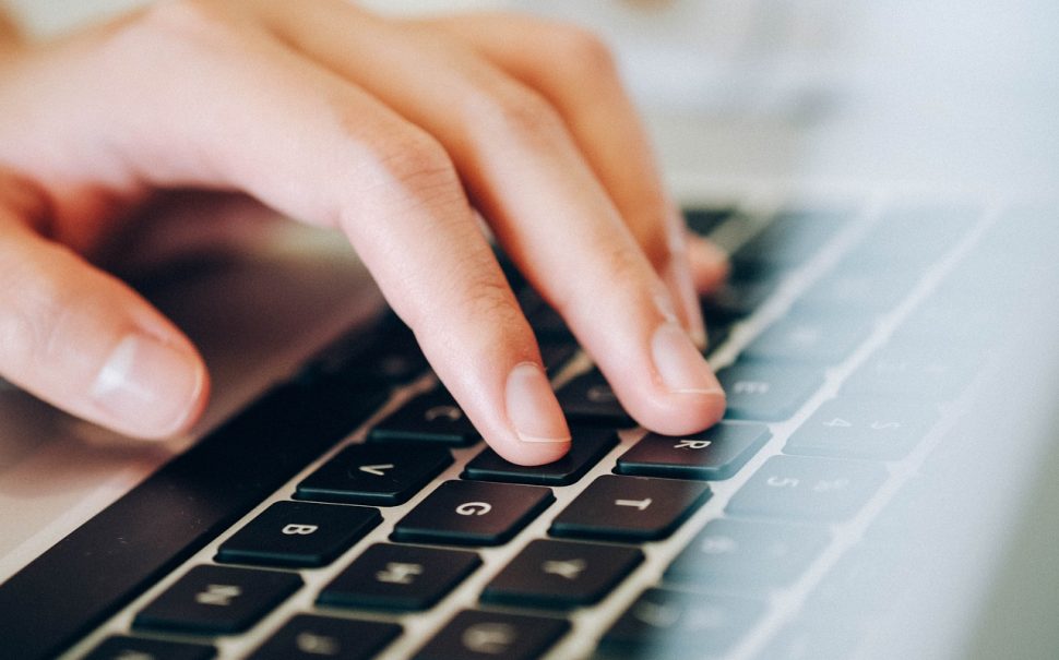 A hand typing on a keyboard